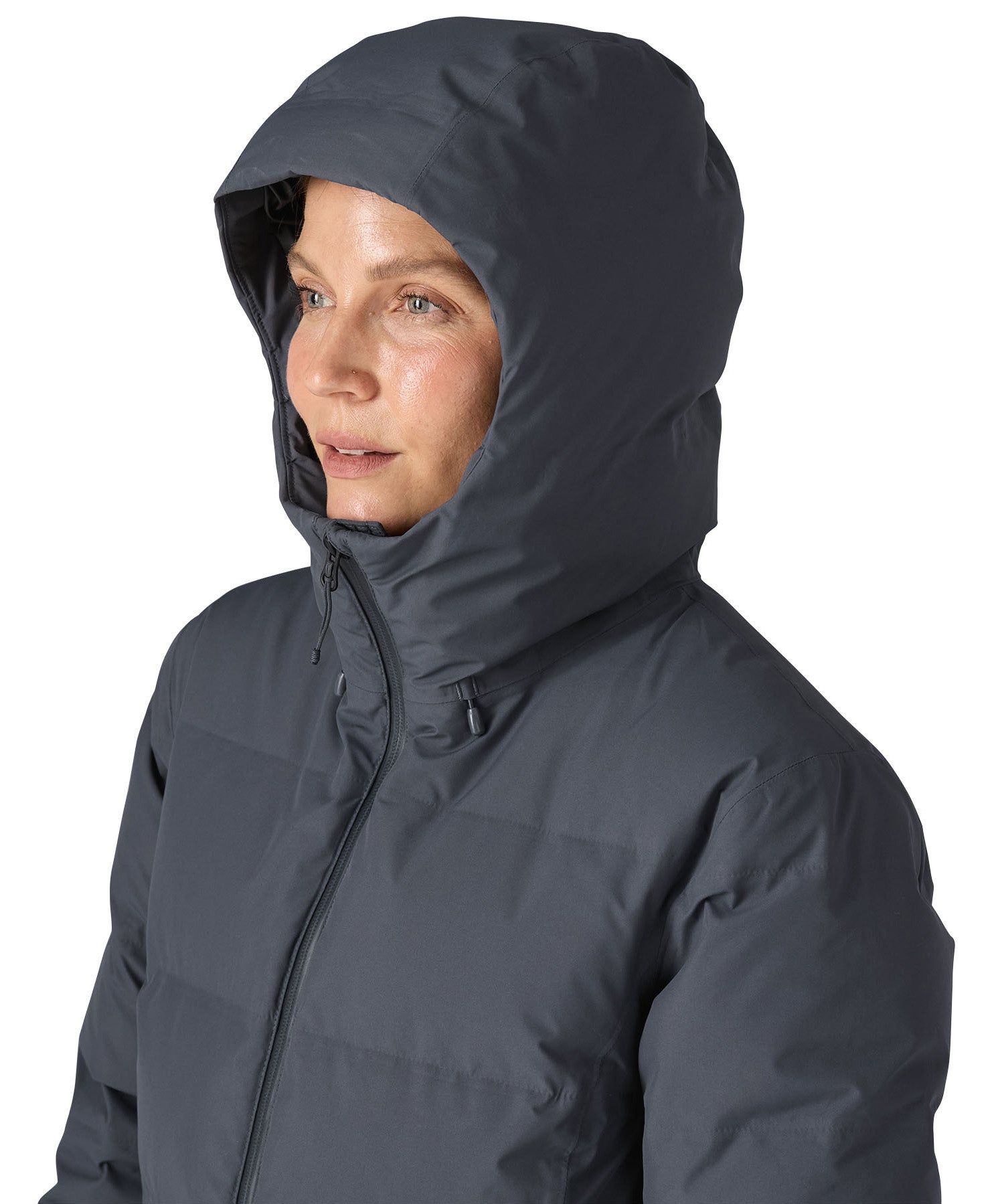 Woman wearing Patagonia Jackson Glacier Parka with hood up and zip fastened up to the chin for maximum insulation.