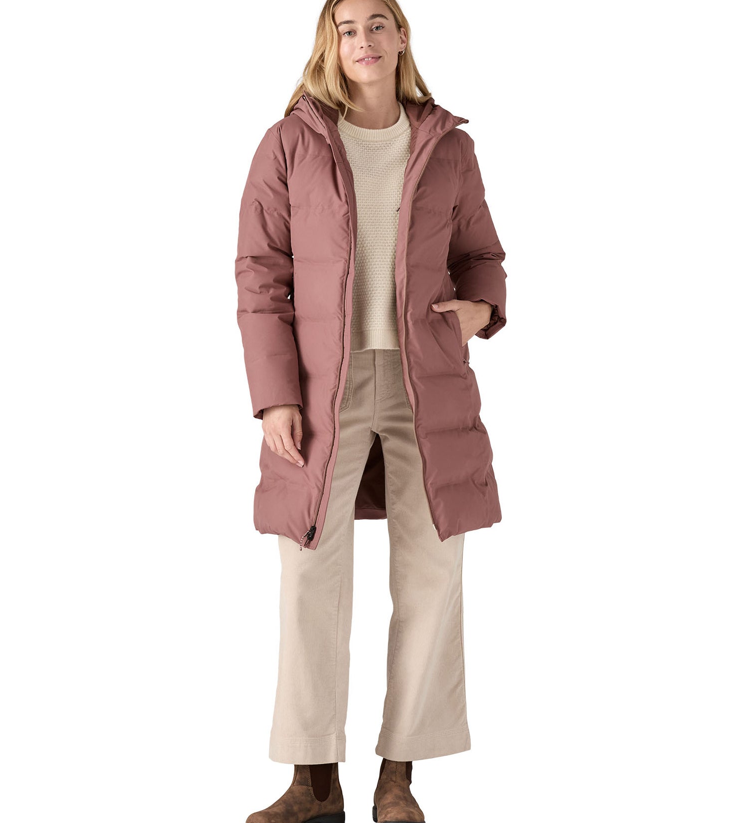 Woman wearing Patagonia Jackson Glacier Parka Coat in pink with the zip open and walking clothing underneath.