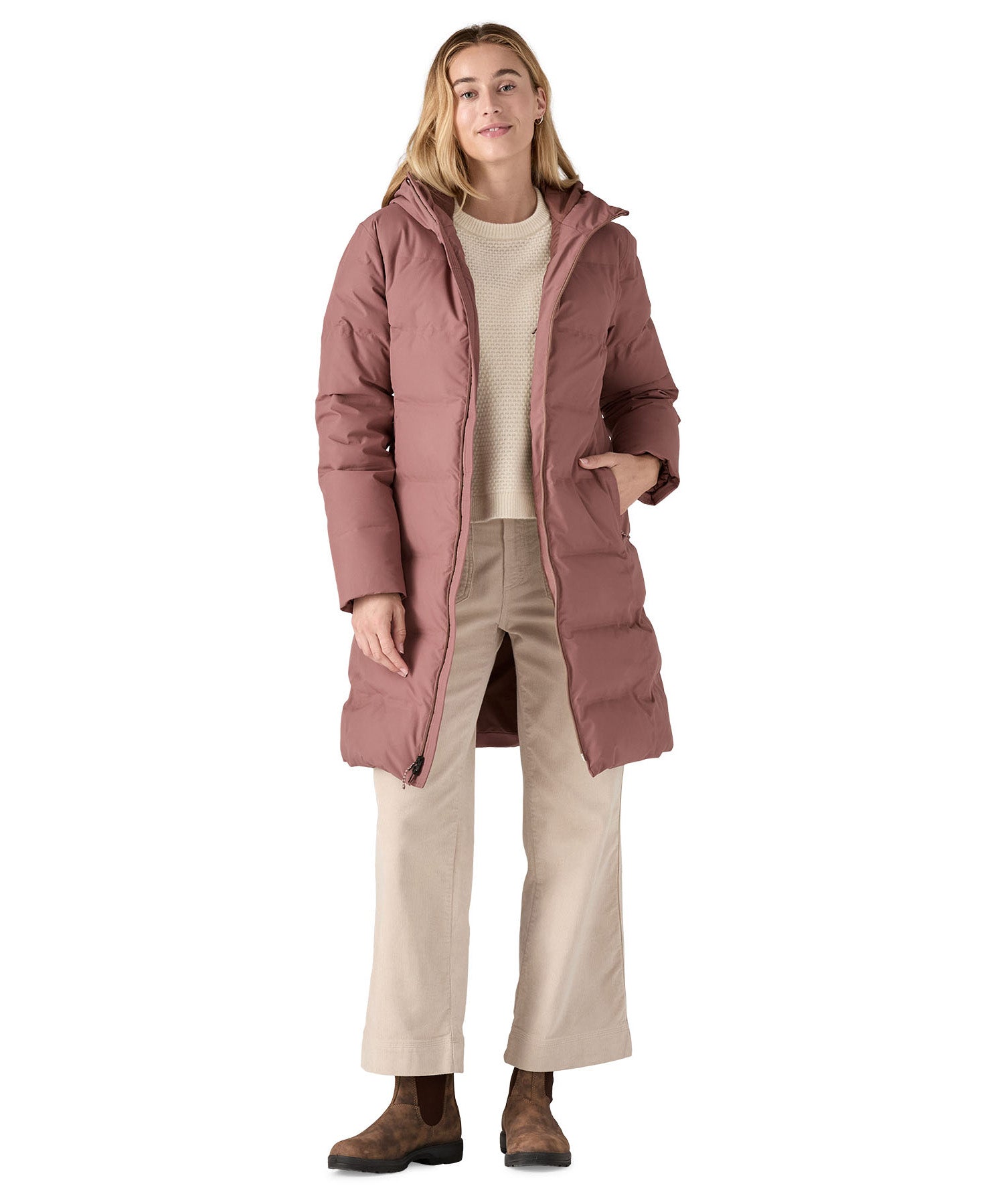 Woman wearing Patagonia Jackson Glacier Parka Coat in pink with the zip open and walking clothing underneath.
