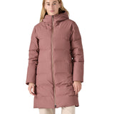 Woman wearing the pink Patagonia Jackson Glacier Parka with the 2-way zip fastened to the chin for insulation.