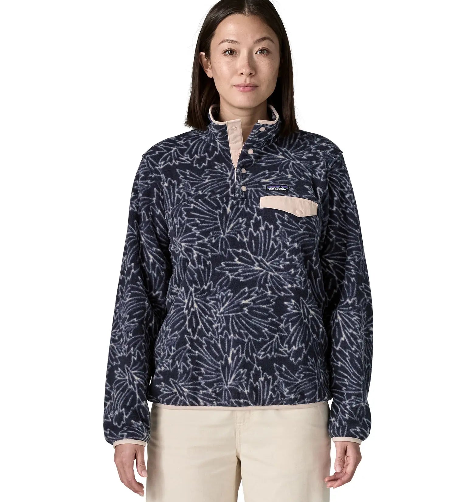 Woman wearing the Patagonia women's lightweight synchilla fleece snap-T pullover with a saxifrage pattern in a sunken blue colour. 