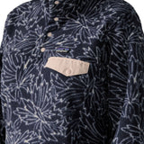 Woman wearing the Patagonia women's lightweight synchilla fleece snap-T pullover with a saxifrage pattern in a sunken blue colour.  Close  up of light pink chest pocket flap.