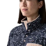 Woman wearing the Patagonia women's lightweight synchilla fleece snap-T pullover with a saxifrage pattern in a sunken blue colour. Close up of popper closure neck.
