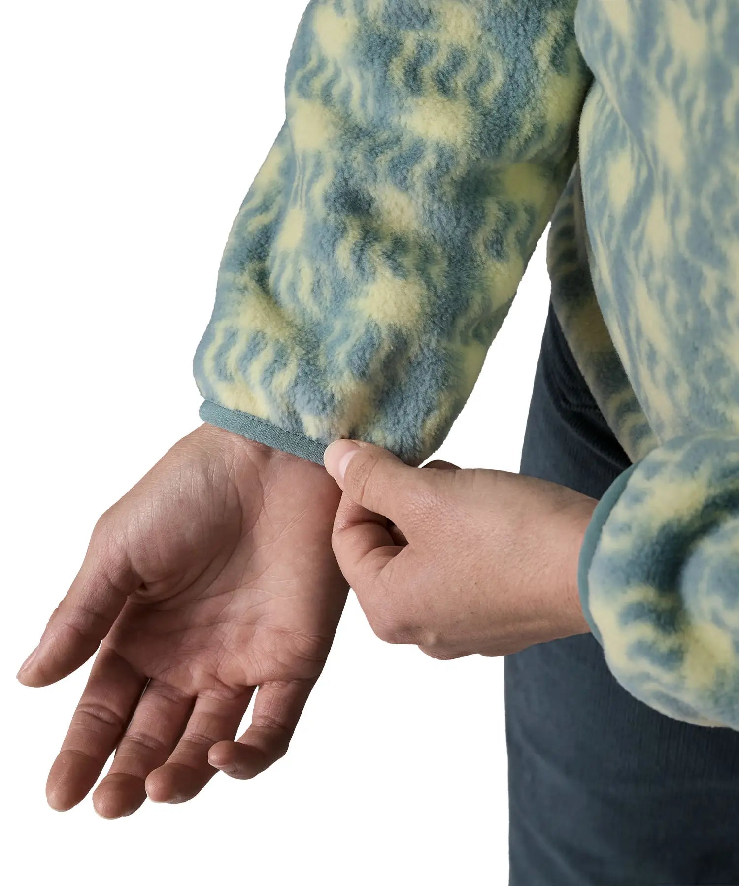 Woman wearing the Patagonia women's lightweight synchilla fleece snap-T pullover in a sun Quilt pattern in blue sage. Close up of sleeve cuffs.