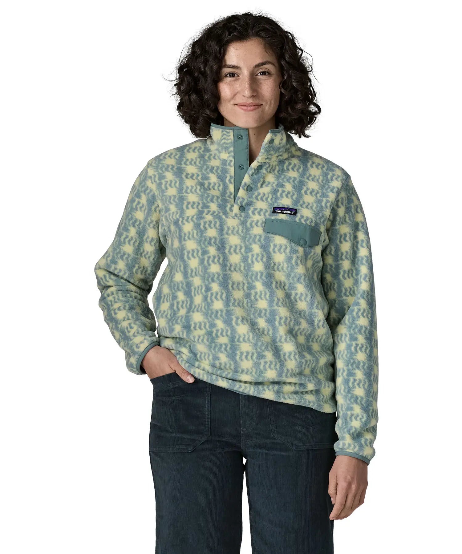 Woman wearing the Patagonia women's lightweight synchilla fleece snap-T pullover in a sun Quilt pattern in blue sage with the poppered neck closure open.