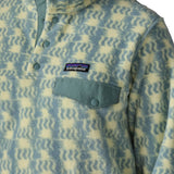 Woman wearing the Patagonia women's lightweight synchilla fleece snap-T pullover in a sun Quilt pattern in blue sage, close up of sage green chest pocket flap.