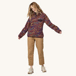 A woman wears the Patagonia Women's Lightweight Synchilla Snap-T Fleece Pullover - against a plain background.
