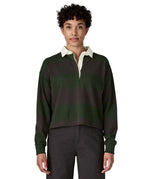 Woman waering a Patagonia women's long sleeved wide stripe rugby shirt in dark green.