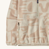 A close up of the Patagonia Women's Synchilla Fleece Marsupial - Mother Tree / Dyno White is a neutral colour fleece with light pink patterns available at Babipur showing the side pocket and design detail