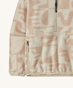 A close up of the Patagonia Women's Synchilla Fleece Marsupial - Mother Tree / Dyno White is a neutral colour fleece with light pink patterns available at Babipur showing the side pocket and design detail