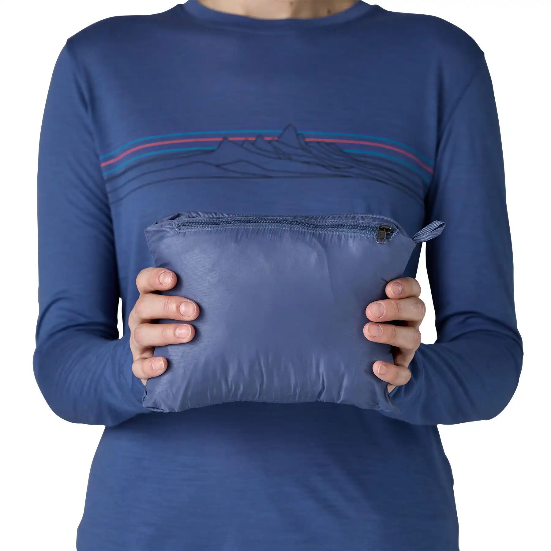 Patagonia Women's Nano Puff Hoody Jacket Current Blue packed into internal chest pocket stuffsack held in hands