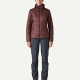Woman wearing the Patagonia Women’s Nano Puff Hoody in Dark Ruby, lightweight insulated recycled polyester jacket for hiking and outdoor wear.