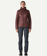 Woman wearing the Patagonia Women’s Nano Puff Hoody in Dark Ruby, lightweight insulated recycled polyester jacket for hiking and outdoor wear.