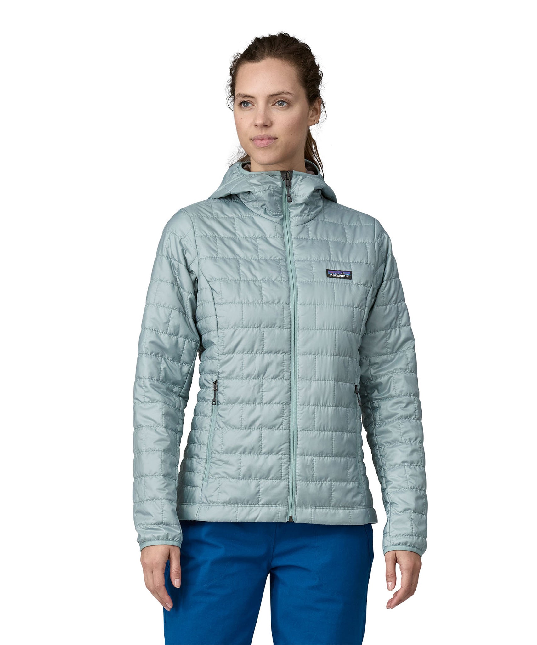 A woman wearing a Patagonia Women's Nano Puff Hoody in Thermal Blue showing the front of the jacket. The front is fully zipped up. 