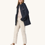 A woman wearing a Patagonia Women's Outdoor Everyday Rain Jacket in a Pitch Blue colour. The zip of the coat is fully open.