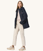 A woman wearing a Patagonia Women's Outdoor Everyday Rain Jacket in a Pitch Blue colour. The zip of the coat is fully open.
