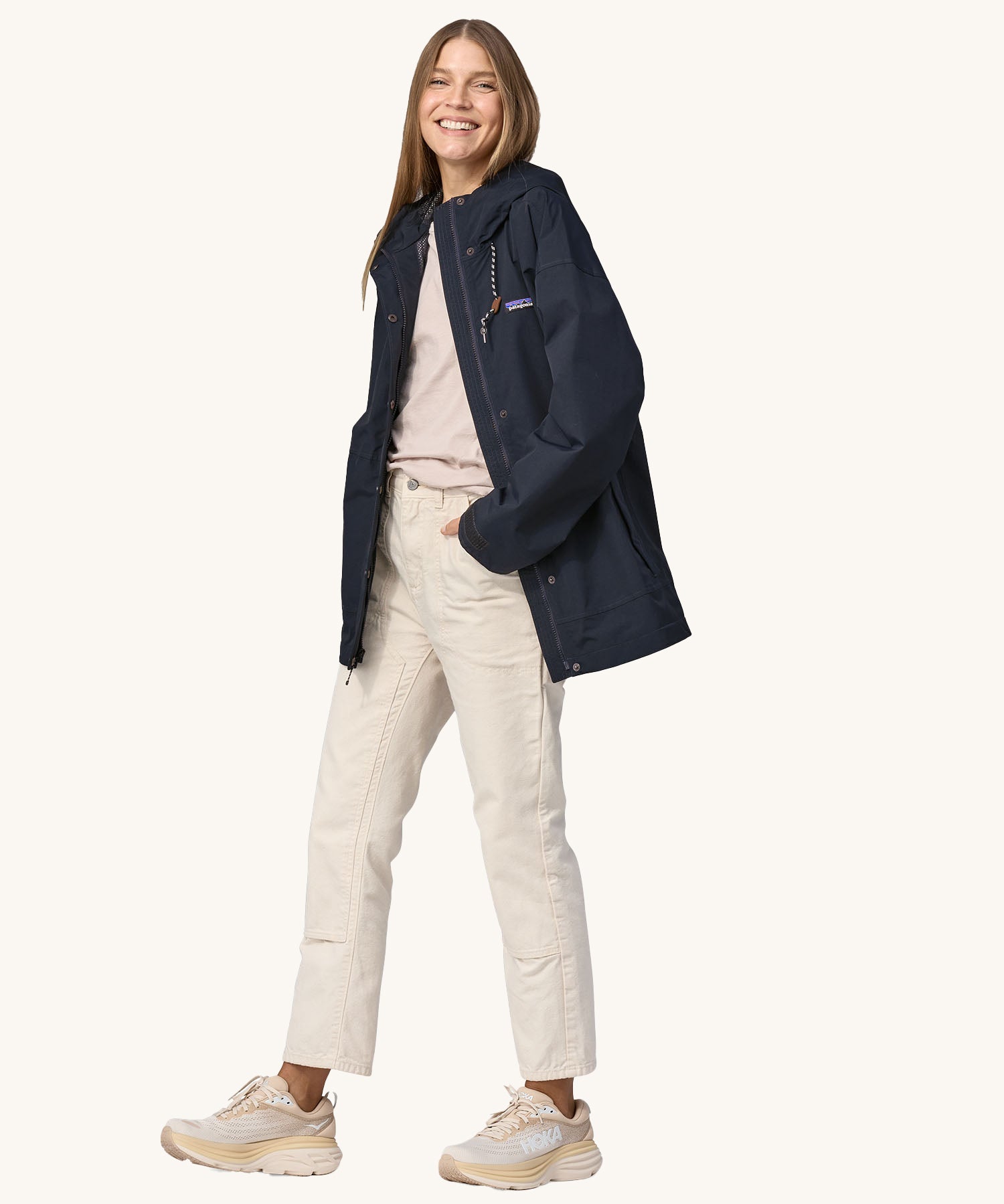 A woman wearing a Patagonia Women's Outdoor Everyday Rain Jacket in a Pitch Blue colour. The zip of the coat is fully open.