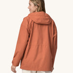 A woman wearing the Patagonia Women's Outdoor Everyday Rain Jacket in a Sienna Clay colour.
