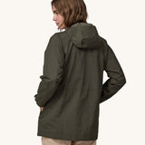 A woman wearing a Patagonia Women's Outdoor Everyday Rain Jacket in a Pine Needle Green colour. The woman is facing away from the camera showing the back of the jacket. 