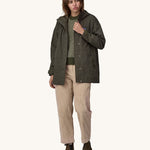 A woman wearing a Patagonia Women's Outdoor Everyday Rain Jacket in a Pine Needle Green colour. The zip of the coat is fully open.