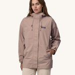 A woman wearing a Patagonia Women's Outdoor Everyday Rain Jacket in a Stingray Mauve colour. 