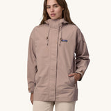 A woman wearing a Patagonia Women's Outdoor Everyday Rain Jacket in a Stingray Mauve colour. 