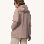 A woman wearing a Patagonia Women's Outdoor Everyday Rain Jacket in a Stingray Mauve colour. The woman is facing away from the camera showing the back of the jacket. 