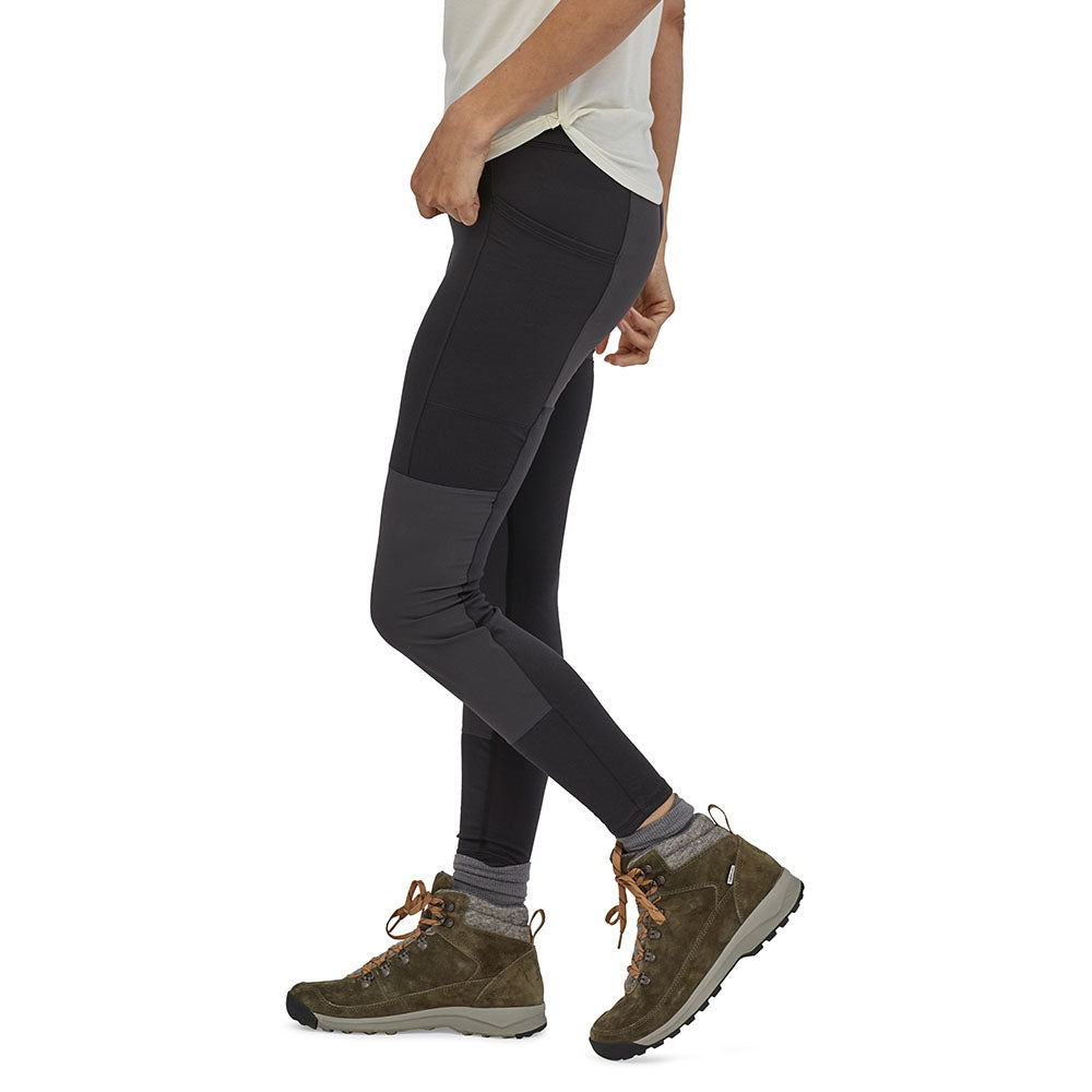 Close up of woman's legs stood sideways on a white background wearing the eco-friendly Patagonia pack out hike tights in the black colour