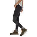 Close up of woman's legs stood sideways on a white background wearing the eco-friendly Patagonia pack out hike tights in the black colour