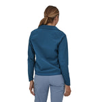 Woman wearing a Patagonia Women's R1 CrossStrata Jacket in a dark blue colour showing the back of the jacket