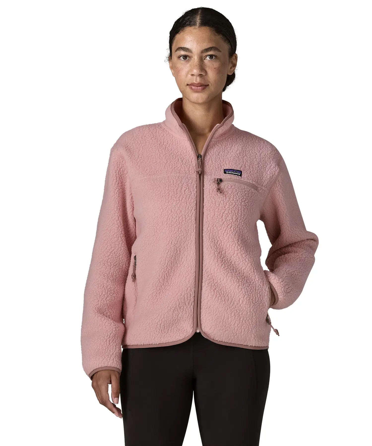 Woman wearing the Patagonia women's retro pile fleece jacket in fuzzy mauve pink. Full zip fleece jacket with zippererd chest and hand warmer pockets.