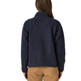 Back of woman wearing Patagonia women's retro pile fleece jacket in sunken blue with zippered chest pocket and handwarmer pockets.