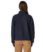 Back of woman wearing Patagonia women's retro pile fleece jacket in sunken blue with zippered chest pocket and handwarmer pockets.