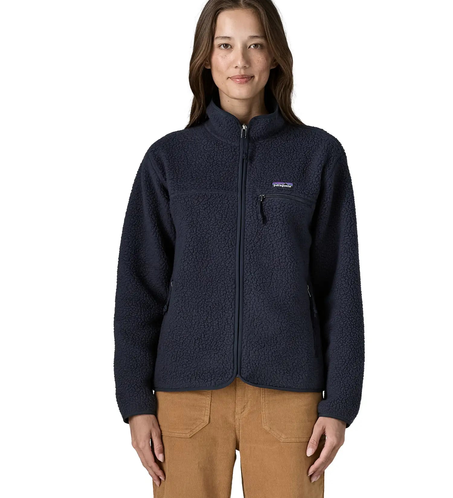 Woman wearing Patagonia women's retro pile fleece jacket in sunken blue with zippered chest pocket and handwarmer pockets.