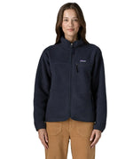 Woman wearing Patagonia women's retro pile fleece jacket in sunken blue with zippered chest pocket and handwarmer pockets.