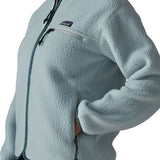Close up of woman wearing the Patagonia women's retro pile fleece jacket in virtually blue with a hand in the hand warmer pocket.