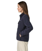 Side view of a woman wearing the Patagonia women's retro pile fleece marsupial top in dark sunken blue.