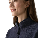 Woman wearing the Patagonia women's retro pile fleece marsupial top in dark sunken blue. Close up of half zip on front.