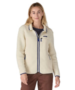 A woman wearing the Patagonia women's retro pile fleece i natural colour available at Babipur. A thick light purple fleece with a contrast blue trim. Features a full length zip, 2 side pockets and a chest pocket with the brand patch stitched above.