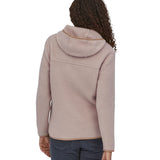 A woman with long curly hair wearing a  Patagonia Women's Retro Pile Hoody Shroom Taupe showing the back of the jacket.