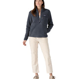 A woman with dark long hair wearing a Patagonia Women's Retro Pile Marsupial jacket in a grey colour