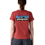 A woman wearing the Patagonia sequoia red short sleeve shirt showing the large brand logo printed on the back of the t-shirt