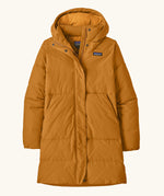Patagonia women's sisar down insulated parka in cinnamon brown with two large front pockets.