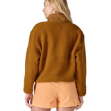 A woman wearing a mustard yellow coloured Patagonia Women's Synchilla Fleece Marsupial Pullover showing the back of the top.