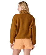 A woman wearing a mustard yellow coloured Patagonia Women's Synchilla Fleece Marsupial Pullover showing the back of the top.