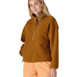 A woman wearing a mustard yellow coloured Patagonia Women's Synchilla Fleece Marsupial Pullover.