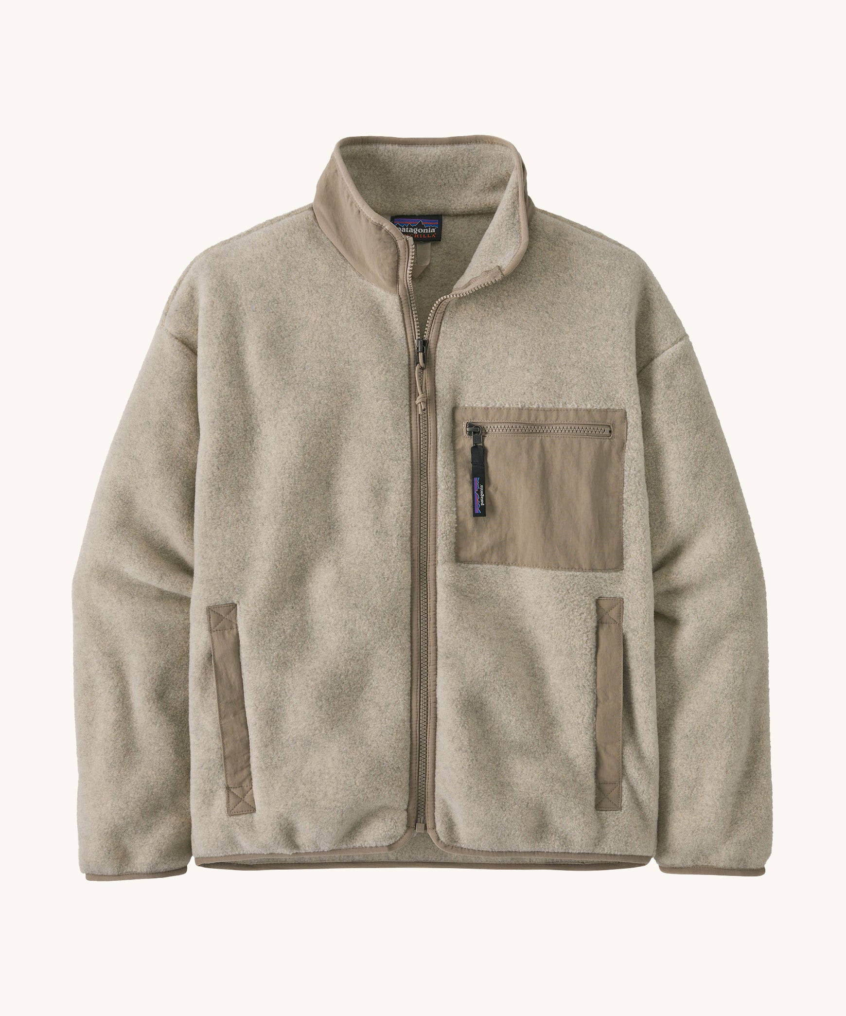 The Patagonia Women's Synchilla® Fleece Jacket in Oatmeal Heather / Seabird Grey is a pale oatmeal full zip fleece jacket with darker beige contrasting binding, patch pocket and collar. Made from Synchilla® 100% recycled fleece.