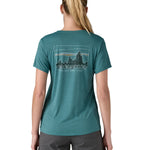 patagonia women's capilene top in a turquoise colour with logo design worn by a woman back detail