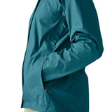 Close up of a woman wearing the Patagonia women's waterproof torrentshell 3L rain jacket in glacial blue with hands in the handwarmer pockets.