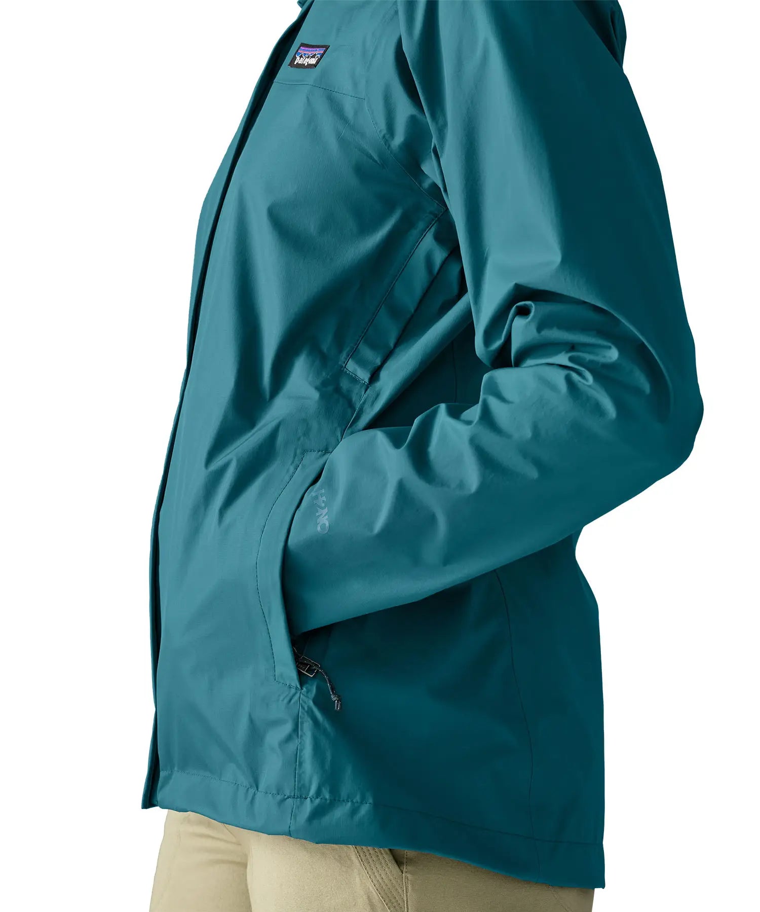 Close up of a woman wearing the Patagonia women's waterproof torrentshell 3L rain jacket in glacial blue with hands in the handwarmer pockets.